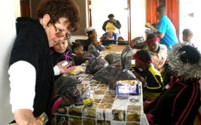 Marie Reid is hier besig met die uitdeel van lekkernye tydens die geselligheid wat sy vir die Gansbaai Elim Huis gereël het 